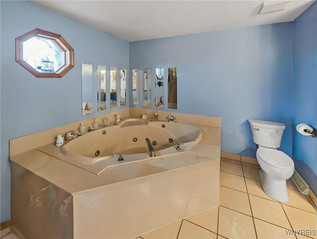 full bathroom featuring a tub with jets, baseboards, tile patterned floors, and toilet