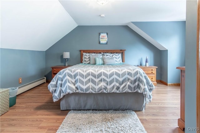 bedroom with light wood finished floors, baseboards, lofted ceiling, and a baseboard radiator