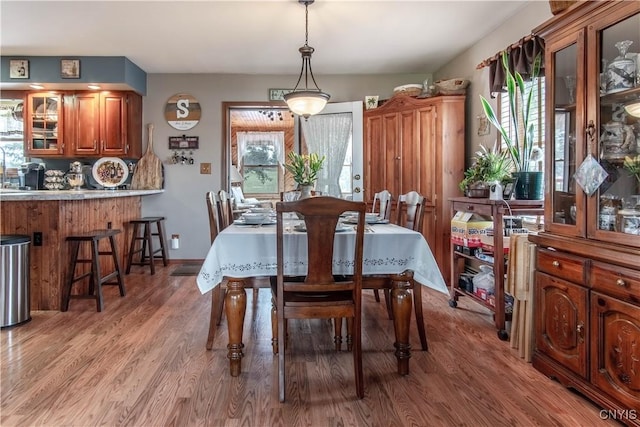 dining area featuring light wood finished floors, baseboards, and plenty of natural light