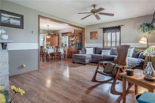 living area with wood finished floors and a ceiling fan