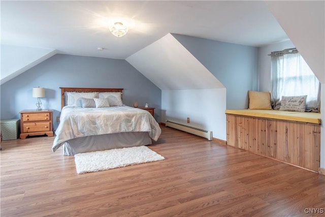 bedroom with wood finished floors, a baseboard heating unit, and vaulted ceiling