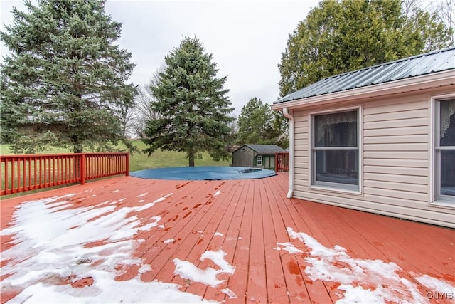 wooden deck with a storage unit and an outbuilding