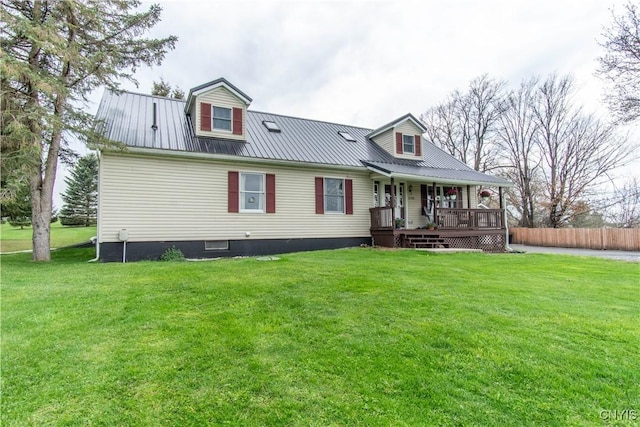 view of front of home with fence, covered porch, metal roof, and a front lawn