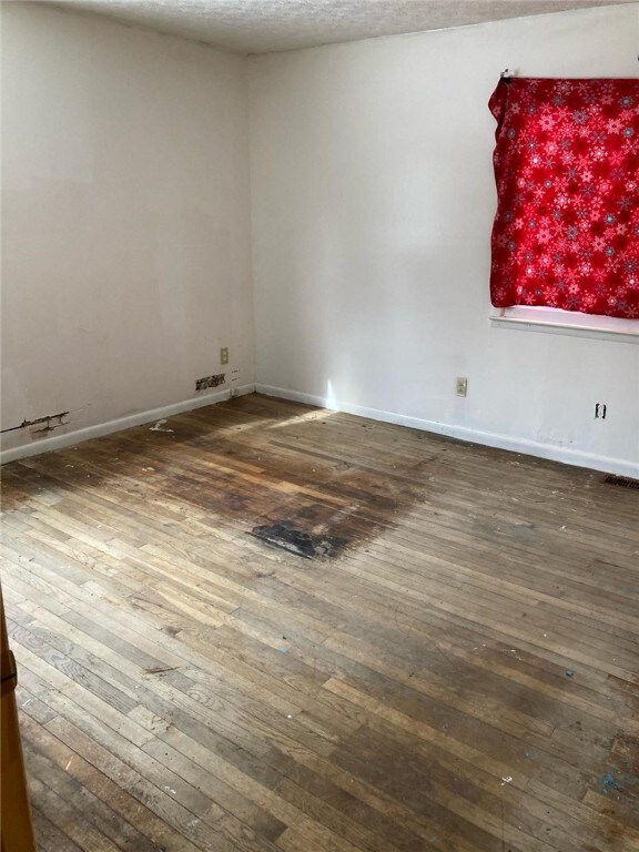 5125 Deliverance Ave, Williamson, NY 14505 - unfurnished room featuring visible vents, baseboards, and hardwood / wood-style flooring