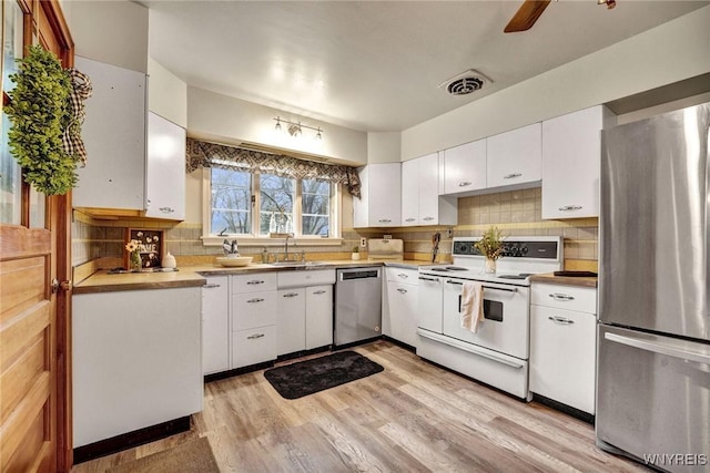339 Lincoln Ave, Lockport-City, NY 14094 - kitchen featuring light wood-style flooring, white cabinetry, visible vents, appliances with stainless steel finishes, and decorative backsplash