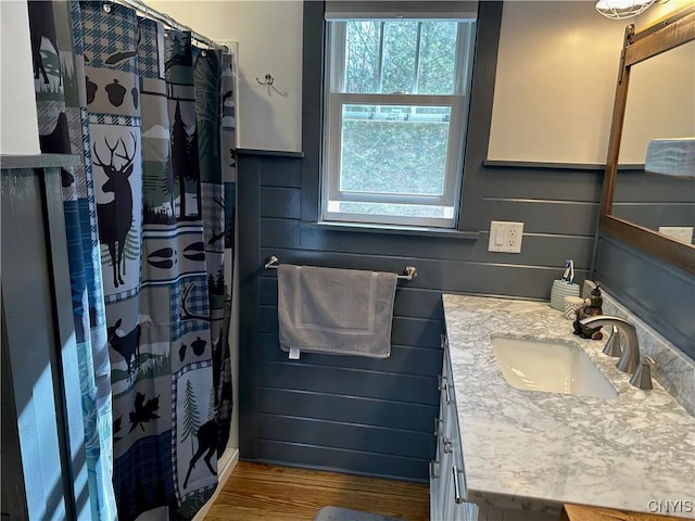bathroom featuring a wealth of natural light, a shower with shower curtain, vanity, and wood finished floors