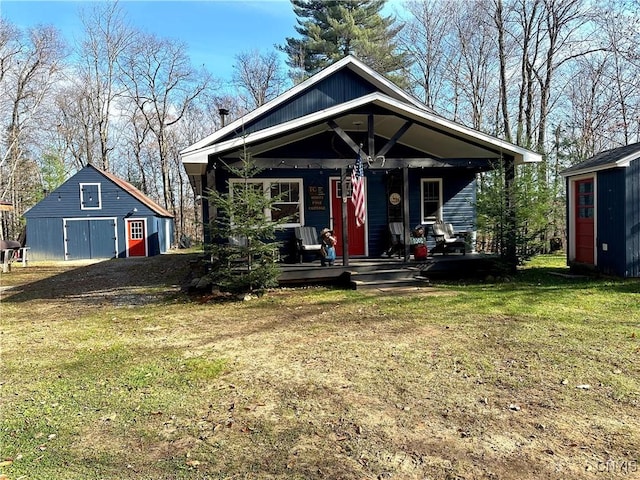 view of front facade with a porch, an outbuilding, and a front yard
