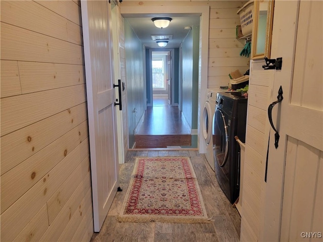 165 Howe St, Le Ray, NY 13612 - laundry room featuring independent washer and dryer, wooden walls, and light wood-type flooring