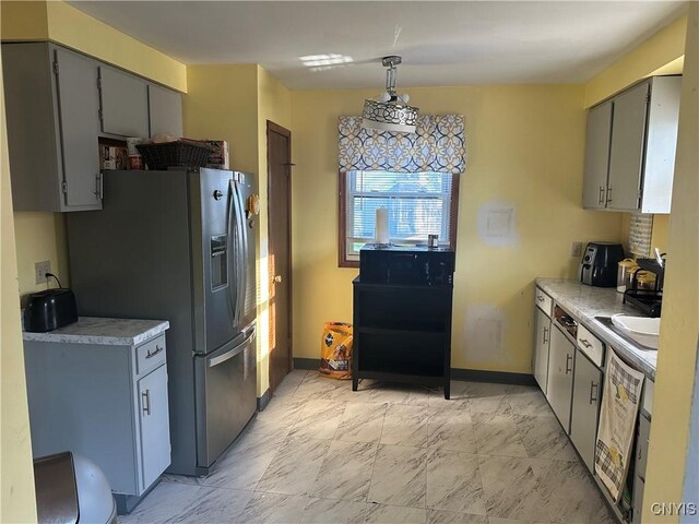 918 Midland Ave, Syracuse, NY 13205 - kitchen with baseboards, gray cabinets, light countertops, stainless steel refrigerator with ice dispenser, and marble finish floor