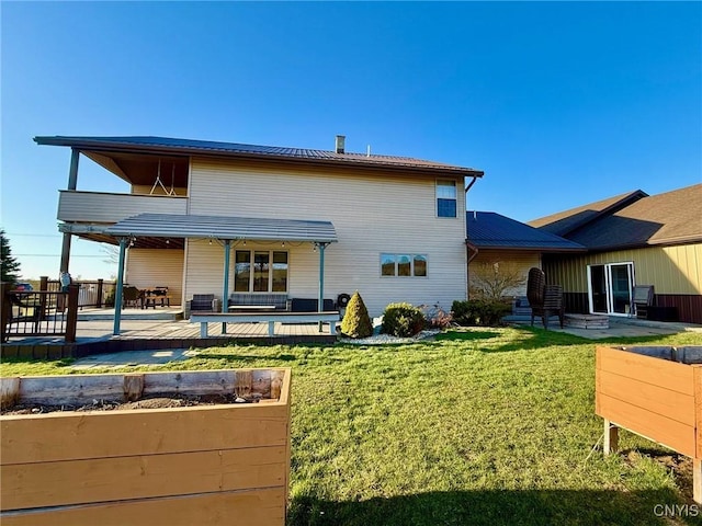 rear view of property with a patio area, metal roof, and a lawn