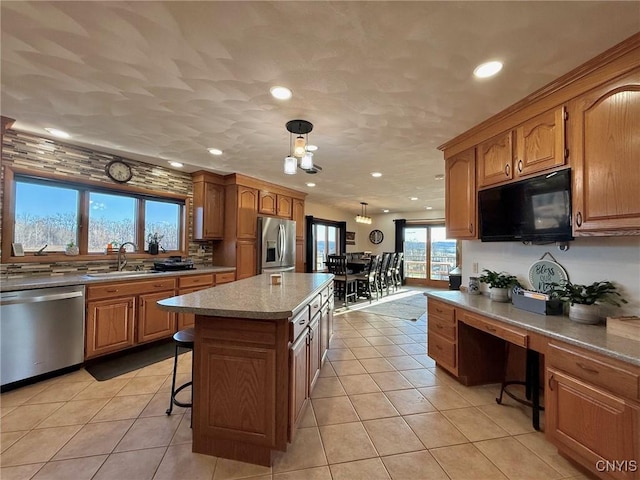 kitchen with recessed lighting, light tile patterned floors, appliances with stainless steel finishes, pendant lighting, and a sink