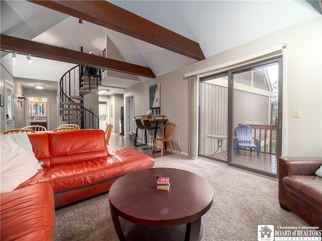carpeted living area with stairway, vaulted ceiling with beams, and a healthy amount of sunlight