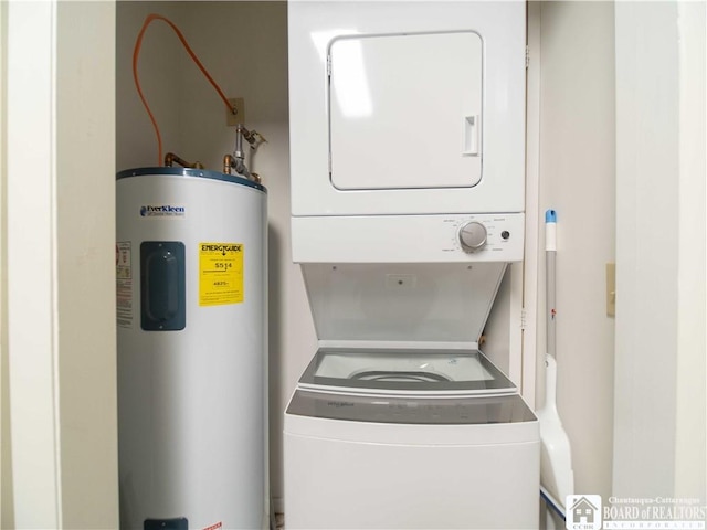 clothes washing area with laundry area, stacked washer and clothes dryer, and water heater