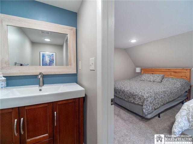 bedroom featuring visible vents, vaulted ceiling, a sink, and carpet floors