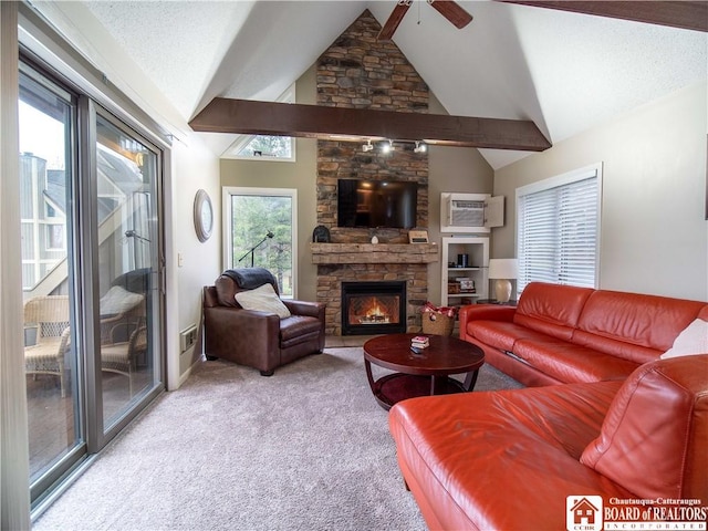 living room with ceiling fan, light colored carpet, a stone fireplace, vaulted ceiling, and a wall mounted air conditioner