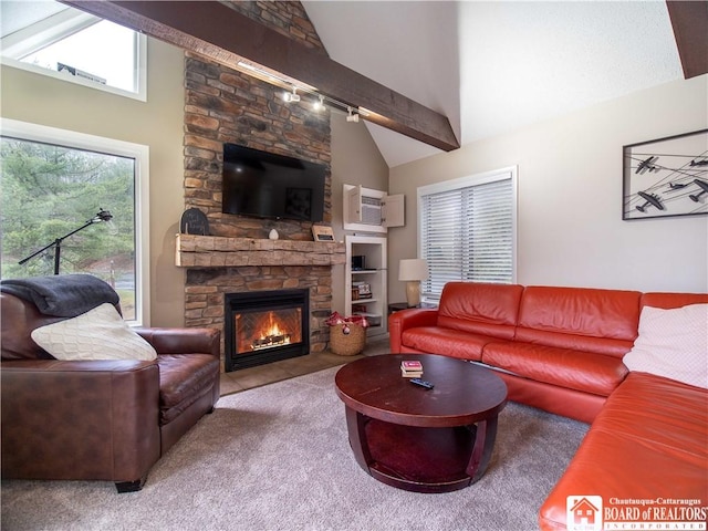 living room with high vaulted ceiling, rail lighting, carpet, a wall unit AC, and a stone fireplace
