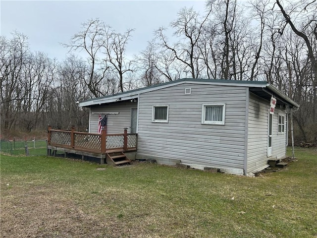 exterior space featuring a wooden deck and a lawn