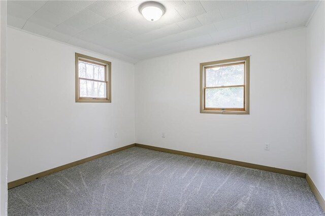 carpeted empty room featuring baseboards