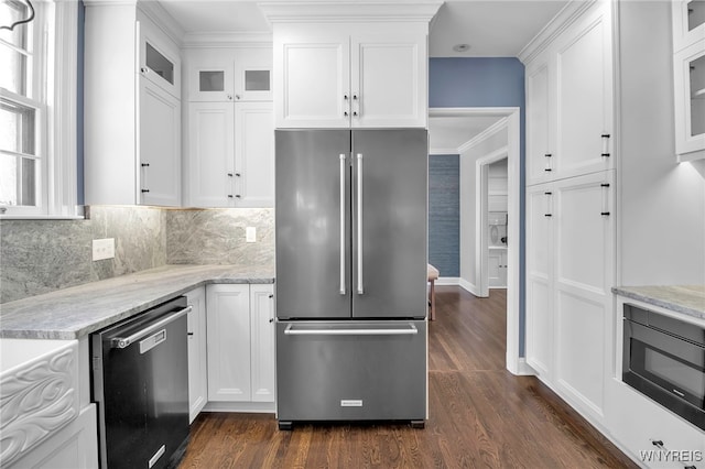 kitchen featuring high end fridge, black microwave, glass insert cabinets, white cabinets, and dishwasher