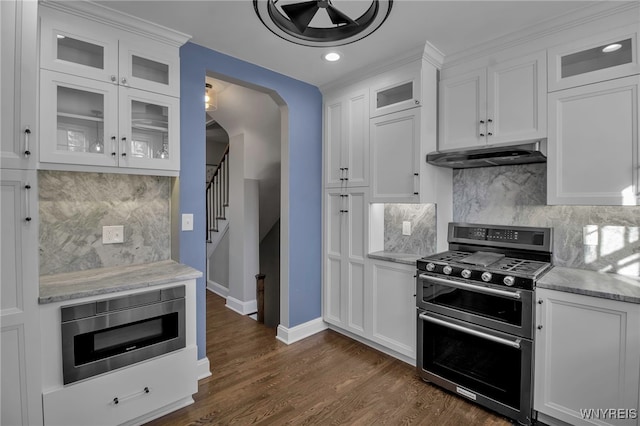 kitchen with tasteful backsplash, baseboards, appliances with stainless steel finishes, and under cabinet range hood