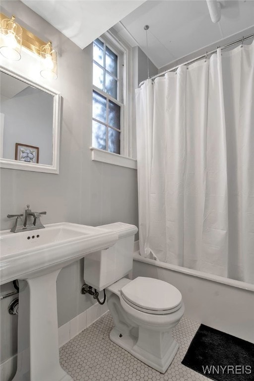 full bath featuring toilet, tile patterned flooring, and shower / bath combination with curtain