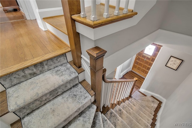 stairway featuring wood-type flooring and baseboards
