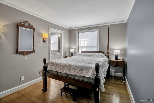 bedroom with wood finished floors, baseboards, ornamental molding, and connected bathroom
