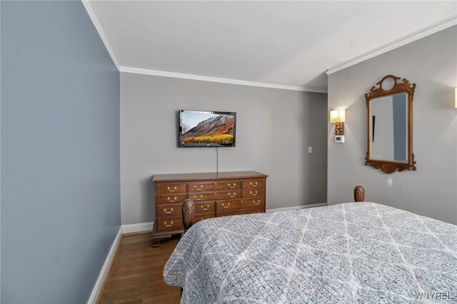 bedroom featuring dark wood-type flooring, crown molding, and baseboards