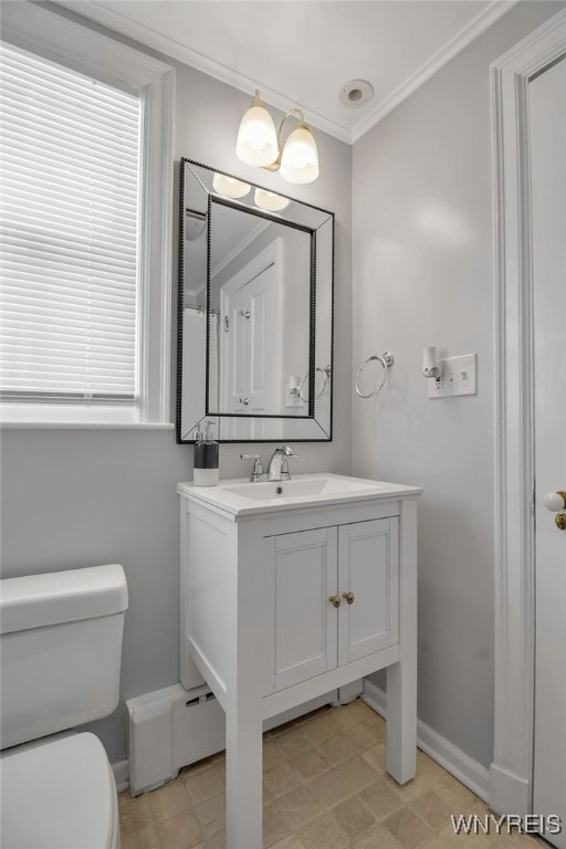 half bath featuring vanity, baseboards, ornamental molding, and toilet