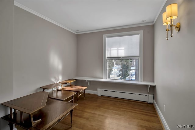 office space with crown molding, baseboards, wood finished floors, and baseboard heating