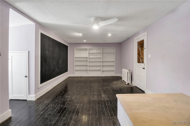 hall featuring radiator heating unit, baseboards, and hardwood / wood-style flooring