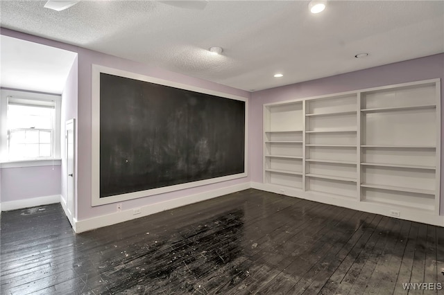 interior space with dark wood-style flooring, baseboards, and a textured ceiling