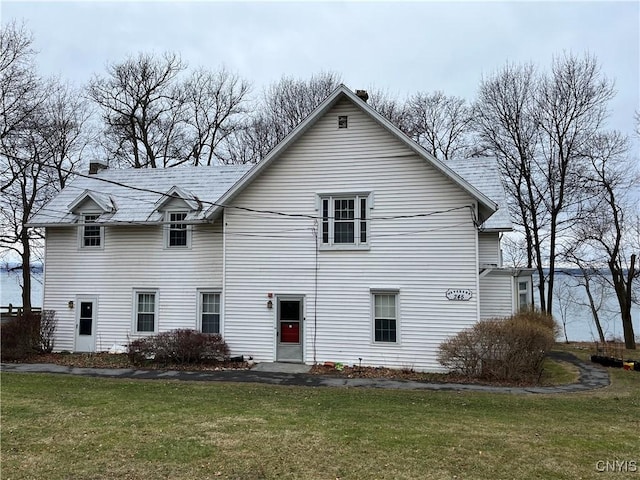 exterior space featuring a chimney and a lawn