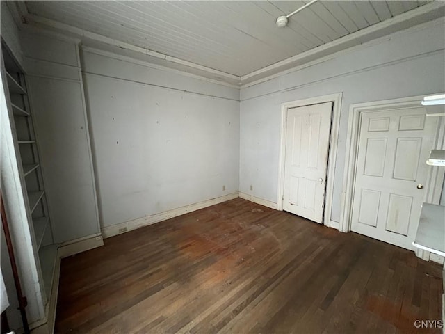 unfurnished bedroom featuring baseboards, wooden ceiling, and wood finished floors