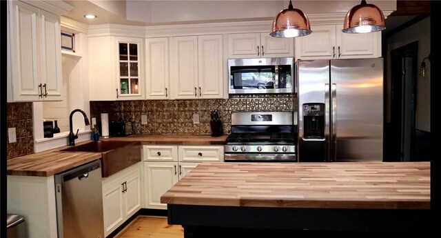 16441 W Lake Rd, Pulteney, NY 14418 - kitchen with white cabinets, appliances with stainless steel finishes, a sink, wooden counters, and decorative backsplash