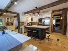 16441 W Lake Rd, Pulteney, NY 14418 - kitchen featuring white cabinetry, beamed ceiling, and a kitchen bar