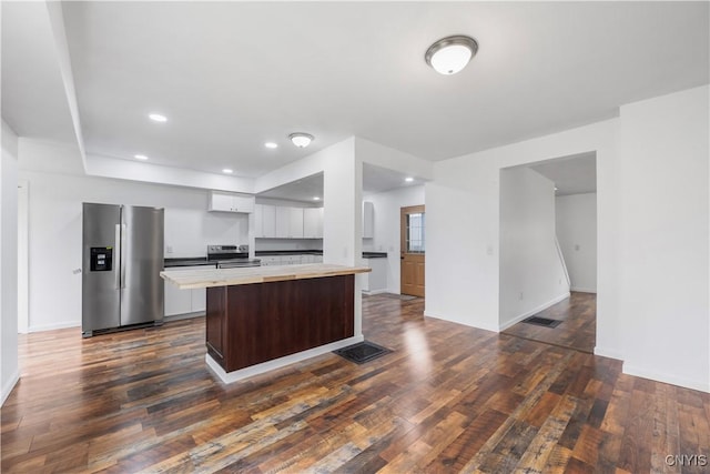 kitchen featuring dark wood-style flooring, visible vents, appliances with stainless steel finishes, light countertops, and white cabinets