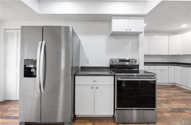 kitchen featuring dark countertops, appliances with stainless steel finishes, white cabinets, and dark wood-type flooring