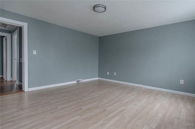 spare room featuring visible vents, baseboards, and light wood-style floors