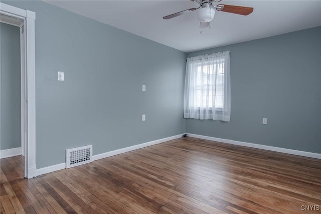 empty room with visible vents, baseboards, a ceiling fan, and wood finished floors