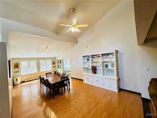 dining room with light wood-style floors, high vaulted ceiling, a ceiling fan, a baseboard radiator, and baseboards