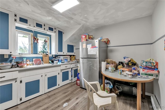 192 Pine St, Lockport City, NY 14094 - kitchen with light countertops, freestanding refrigerator, white cabinetry, light wood-style floors, and a sink