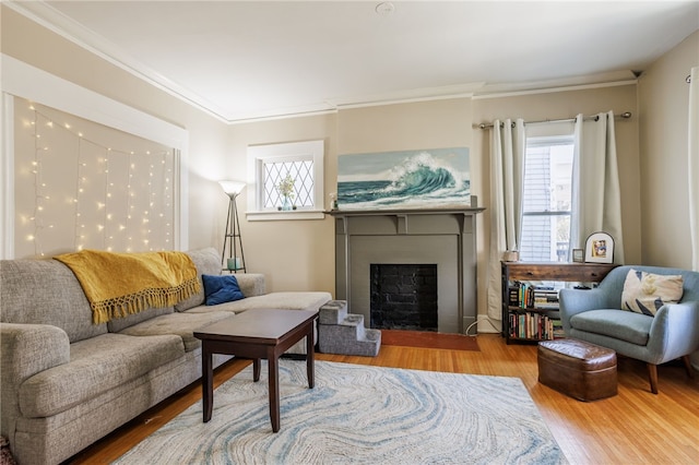 living room featuring crown molding, wood finished floors, and a fireplace with flush hearth