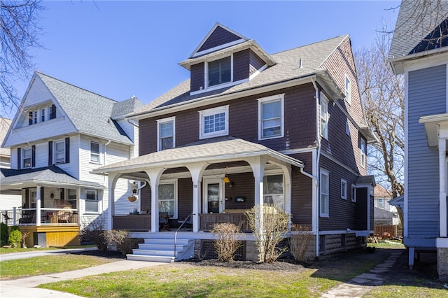 traditional style home featuring roof with shingles and a porch
