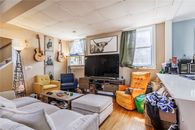 living room with wood-type flooring and a paneled ceiling