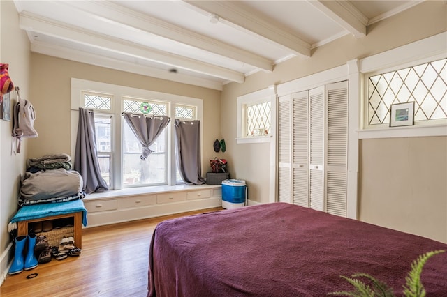 bedroom featuring a closet, beamed ceiling, and wood finished floors