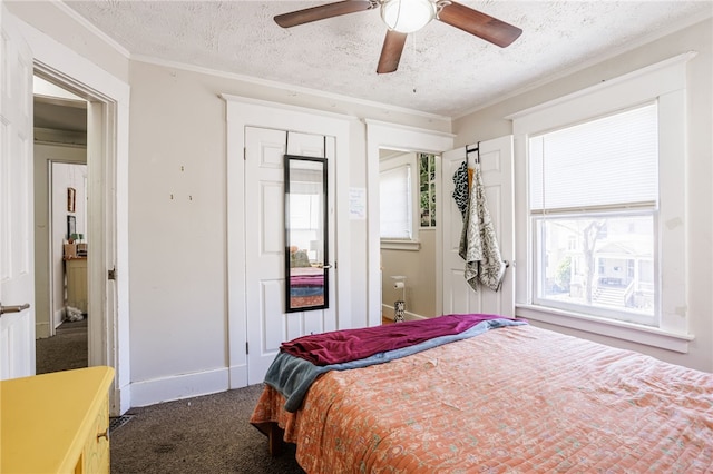 bedroom featuring a textured ceiling, ceiling fan, ornamental molding, and carpet floors