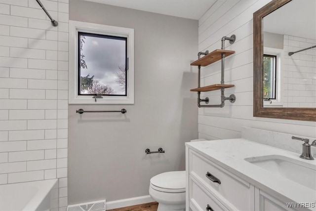 bathroom featuring vanity, toilet, shower / bathtub combination, visible vents, and wood finished floors