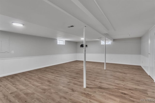 basement featuring visible vents and wood finished floors