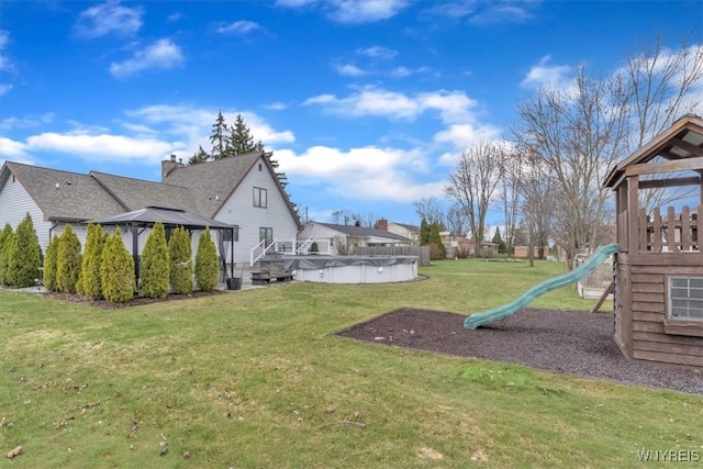 view of yard with a fenced in pool and a playground